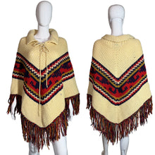 Load image into Gallery viewer, Beige poncho with patterned front and fringes on a mannequin against a neutral background