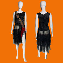 Load image into Gallery viewer, A sleeveless 1920s drop waist black dress with sheer ruffled layered skirt and red sash featuring a diagonal floral embroidery across the bust. Shown on white mannequins from the front and back.