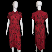 Load image into Gallery viewer, Red dress with black floral pattern on a mannequin against a white wall.