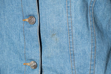 Load image into Gallery viewer, Close-up of a blue denim jacket with button details