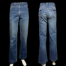 Load image into Gallery viewer, Pair of blue jeans displayed from front and back on mannequins against a white wall.