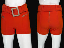 Load image into Gallery viewer, Orange shorts with a belt and silver buckle on white mannequins.