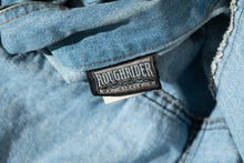 Load image into Gallery viewer, Close-up of a denim jacket with a 'Roughrider' label.