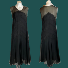 Load image into Gallery viewer, A vintage 1920's black chiffon and lace flapper dress with a straight silhouette, chevron stripes, and an illusion bodice, displayed on a mannequin.