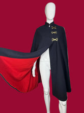 Load image into Gallery viewer, Navy blue cape with gold buckles and red lining on a mannequin against a plain background