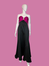Load image into Gallery viewer, Mannequin wearing a black dress with a pink bow on a white platform.