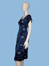 Load image into Gallery viewer, Mannequin wearing a blue dress with floral patterns on a plain background