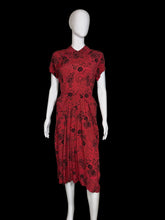 Load image into Gallery viewer, Red dress with black floral pattern on a mannequin against a white wall.