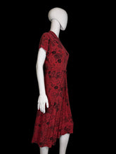 Load image into Gallery viewer, Red dress with black patterns on a white mannequin against a plain background