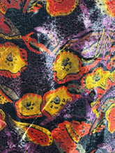 Load image into Gallery viewer, Close-up of a colorful fabric with abstract patterns in red, yellow, and purple on a black background.