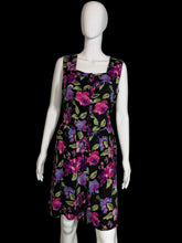 Load image into Gallery viewer, Black romper with colorful floral pattern on a mannequin against a white background