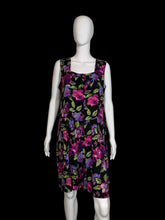 Load image into Gallery viewer, Black romper with colorful floral pattern on a mannequin, shown uncinched against a white background