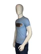 Load image into Gallery viewer, Blue t-shirt with graphic design on a mannequin against a plain background