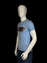 Load image into Gallery viewer, Blue t-shirt with graphic design on a mannequin against a plain background