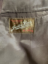 Load image into Gallery viewer, Close-up of a label on a jacket with text and branding.
