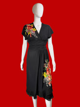 Load image into Gallery viewer, Black dress with floral applique on a mannequin against a neutral background