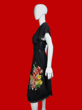 Load image into Gallery viewer, Black dress with floral design on a mannequin against a plain wall.