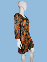 Load image into Gallery viewer, Mannequin wearing a floral dress with orange and black pattern against a plain wall.