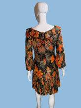 Load image into Gallery viewer, Black and orange floral dress on a mannequin against a white wall.