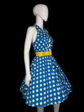 Load image into Gallery viewer, Mannequin wearing a blue dress with white polka dots and a yellow belt on a plain background