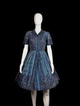 Load image into Gallery viewer, Mannequin wearing a blue patterned dress against a plain wall.