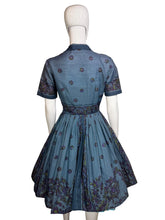 Load image into Gallery viewer, Blue dress with floral patterns on a mannequin against a neutral background