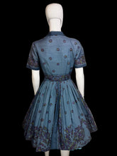 Load image into Gallery viewer, Blue dress with floral patterns on a mannequin against a neutral background