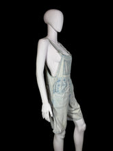 Load image into Gallery viewer, Mannequin wearing light blue denim overalls against a plain wall.