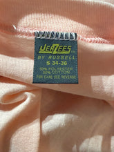 Load image into Gallery viewer, Fabric tag on a light pink garment with 'Jerzees by Russell' branding.