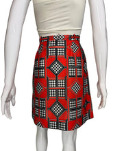 Load image into Gallery viewer, Mannequin wearing a white top and red patterned skort on a plain background.