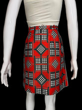 Load image into Gallery viewer, Mannequin wearing a white top and red patterned skort on a plain background.