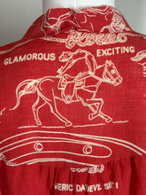 Load image into Gallery viewer, Red top with white graphic of a person on horseback and text.