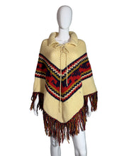 Load image into Gallery viewer, Mannequin wearing a beige poncho with a colorful pattern and fringes on a white background