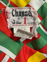 Load image into Gallery viewer, Close-up of a colorful fabric with 'Channel 1' branding and tags.