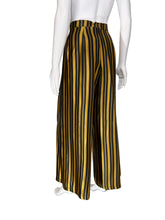 Load image into Gallery viewer, Black and yellow striped pants on mannequins with a neutral background