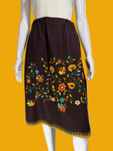 Load image into Gallery viewer, Mannequin wearing a brown skirt with colorful floral embroidery against a plain background.