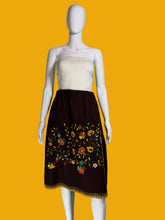 Load image into Gallery viewer, Mannequin wearing a white top and brown skirt with floral embroidery against a plain wall.