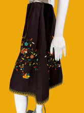 Load image into Gallery viewer, Mannequin wearing a brown garment with colorful floral embroidery on a white background.