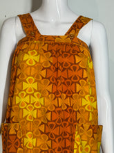 Load image into Gallery viewer, Mannequin wearing a patterned orange and yellow dress with geometric design.