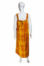 Load image into Gallery viewer, Mannequin wearing an orange patterned dress against a plain wall.