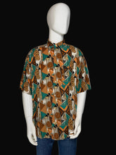 Load image into Gallery viewer, Mannequin wearing a patterned shirt with a brown and teal geometric design