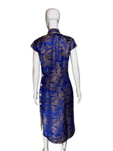 Load image into Gallery viewer, Blue and gold patterned dress on a mannequin against a plain wall.