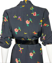 Load image into Gallery viewer, Black jumpsuit with colorful floral pattern on mannequins against a white wall.