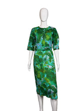 Load image into Gallery viewer, Green patterned dress on a white mannequin against a plain wall.
