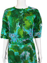 Load image into Gallery viewer, Green patterned dress on a white mannequin against a plain wall.
