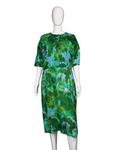 Load image into Gallery viewer, Green patterned dress on a white mannequin against a plain wall.