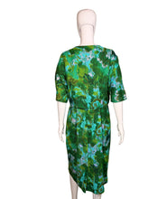 Load image into Gallery viewer, Green patterned dress on a white mannequin against a plain wall.