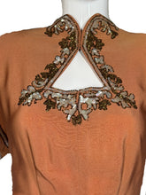 Load image into Gallery viewer, Close-up of a brown garment with intricate gold and silver embroidery.