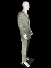 Load image into Gallery viewer, A men's two-piece suit displayed on a white mannequin, featuring a windowpane plaid pattern. The suit includes a button-up jacket and matching trousers, shown in a side profile.
