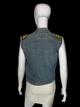 Load image into Gallery viewer, A sleeveless denim vest with yellow and black striped shoulder epaulets, shown from the back on a white mannequin.